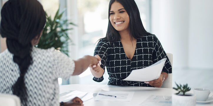 Shot of two young businesswomen shaking hands in a modern office Shot of two young businesswomen shaking hands in a modern office