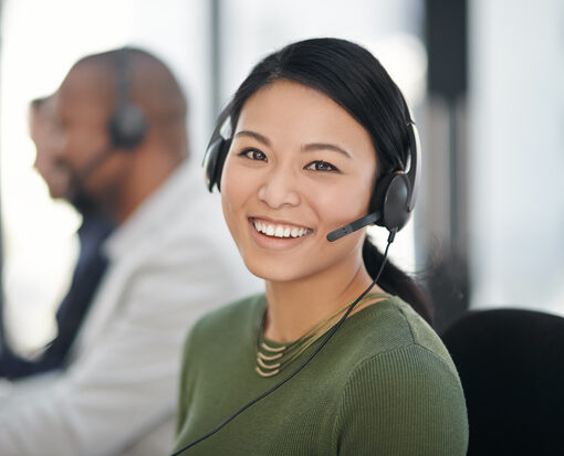 Portrait of a call centre agent working alongside her colleagues in an office