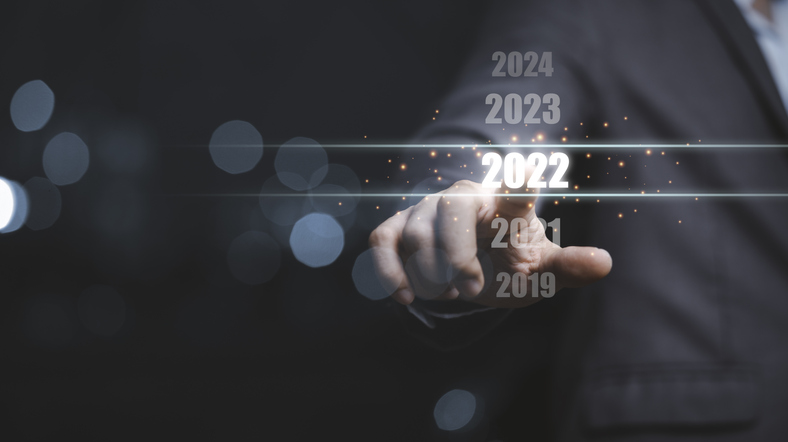 Businessman touching number 2022, moving to 2023 forecast